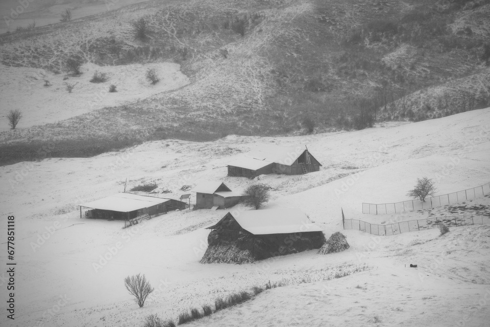 rural winter landscape in the hill area with households and human activities