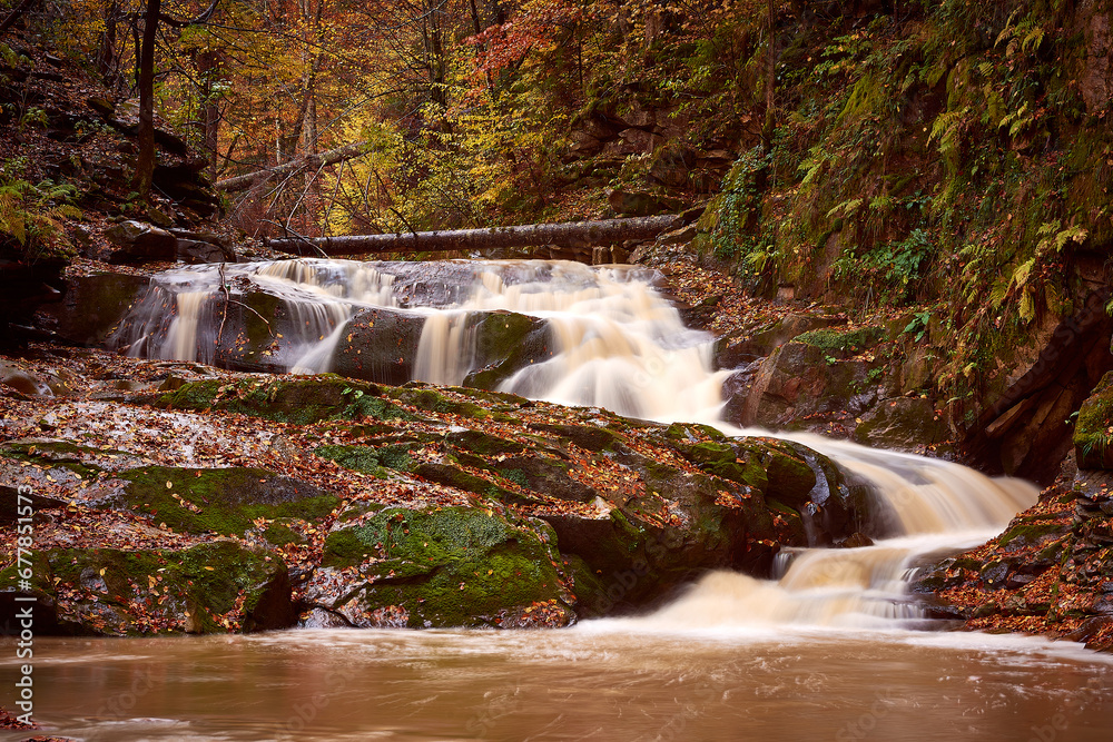 autumn landscape with mountain river and silky waterfall