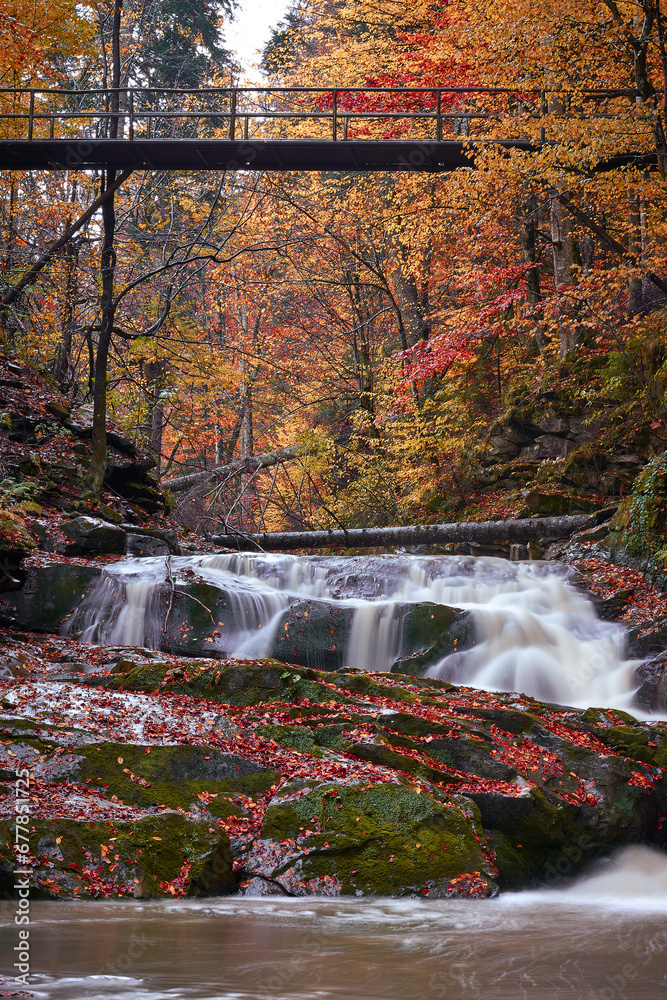 autumn landscape with mountain river and silky waterfall