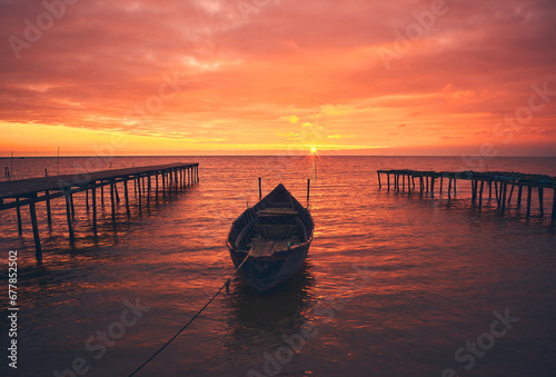 Obraz na płótnie boat at sunrise on the lake w salonie