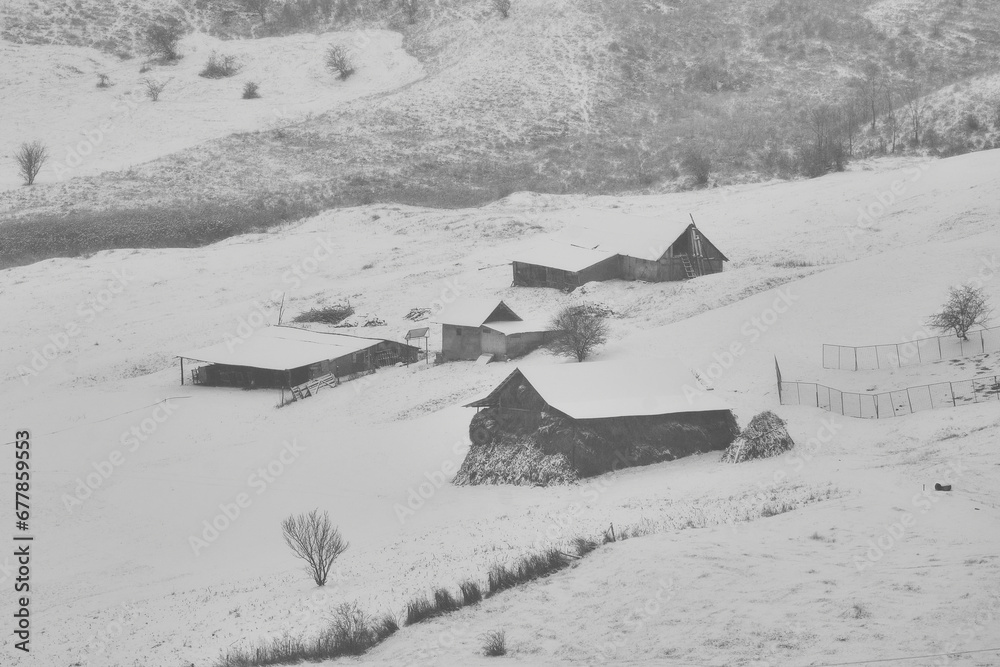 rural winter landscape in the hill area with households and human activities