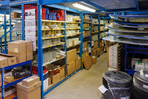  In a car repair shop there are shelves full of spare parts photo