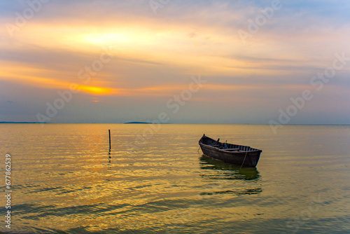 Obraz na płótnie boat at sunrise on the lake w salonie