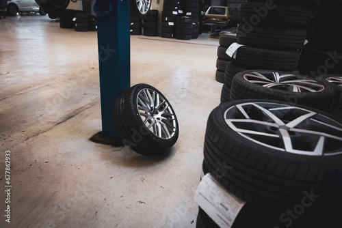 a complete wheel leans against a pillar in a car repair shop photo
