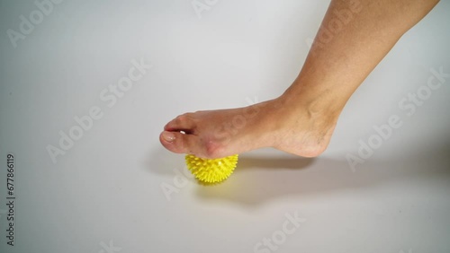 Massage a woman's foot with a yellow ball for hallux valgus. photo