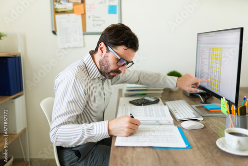 Public accountant with glasses doing taxes at the office photo