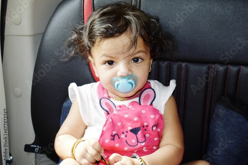 Closeup of a baby with a pacifier looking at the camera photo