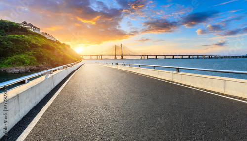 asphalt highway road and bridge at sunset by the sea photo