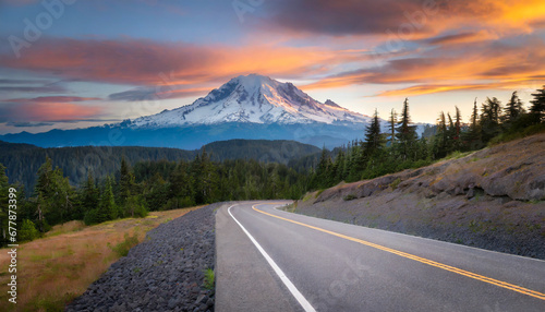 road leading towards mount rainier or tahoma in cascades range with sunset clouds hovering low in sky photo