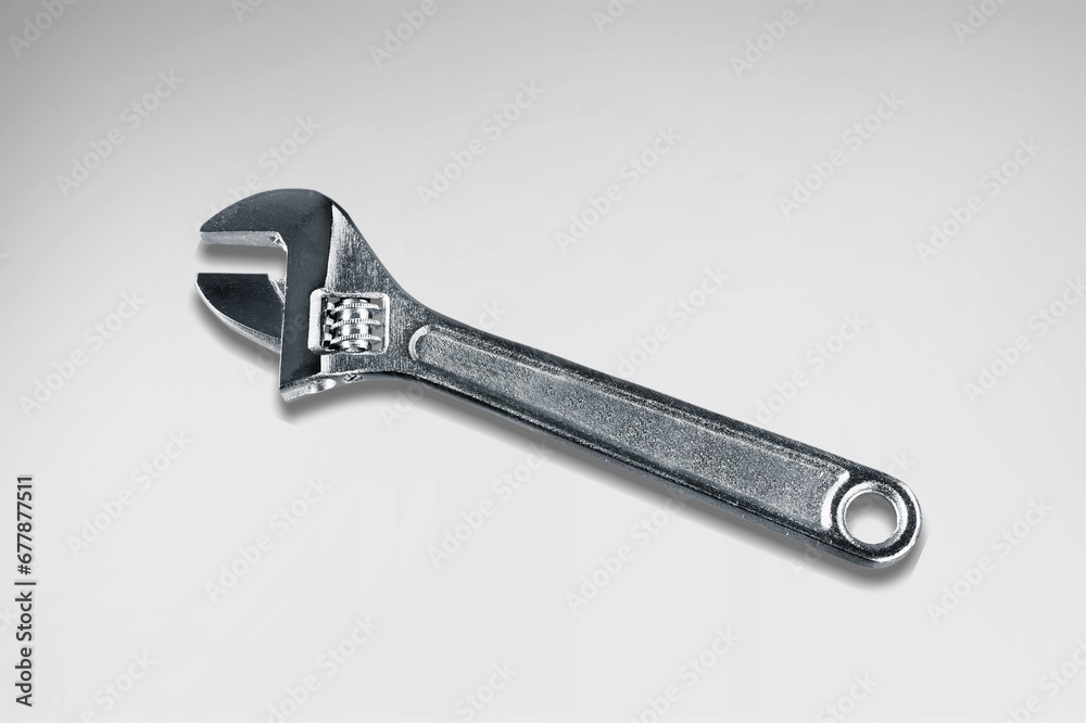 A steel shiny wrench on a light background. A steel shiny wrench on a light background.