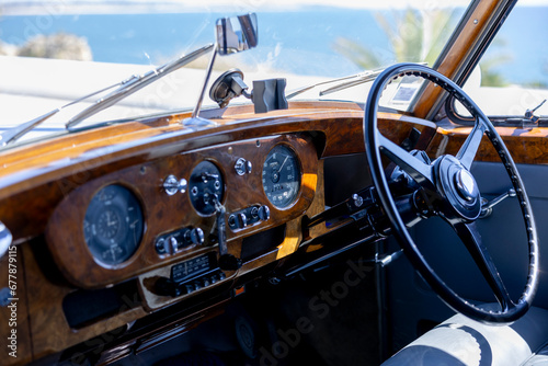 Close up of the steering wheel of an old classic car.