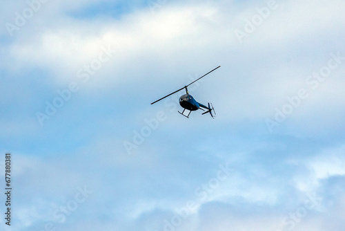 helicopter crosses the blue sky with clouds. Transportation. Urban.