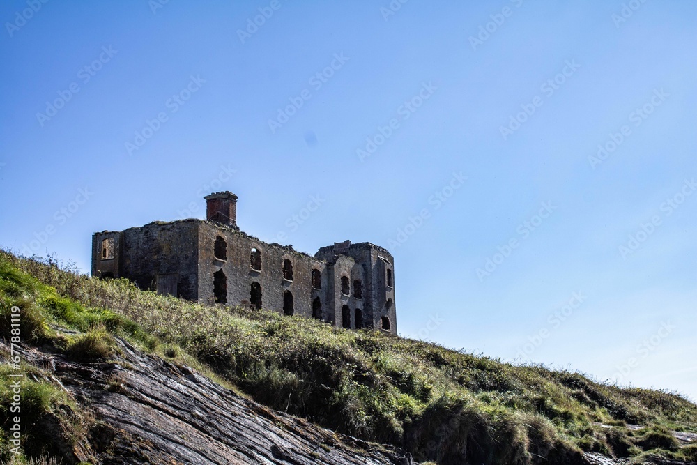 Low angle shot of the ruins of Howe Strand Coast Guard Station under the blue sky