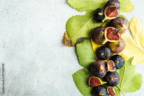 Overhead view of fresh organic figs on an arrangement of fig leaves photo