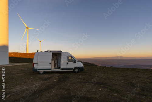 Wind turbines at Serra da Arada over mountain landscape at evening sunset with camper van on road trip, Sao Pedro do Sul, Portugal photo