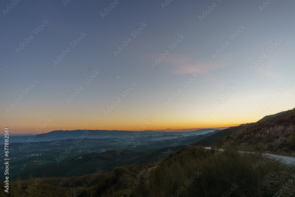 View from Serra da Arada over mountain landscape at evening twilight with crescent moon, Sao Pedro do Sul, Portugal