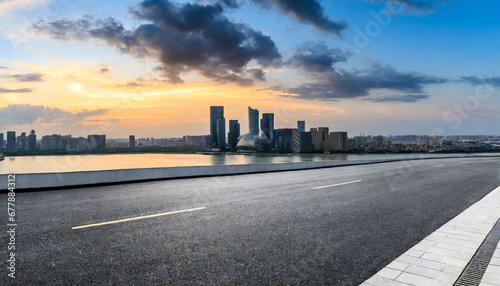 asphalt road and city skyline with modern building at sunset in suzhou jiangsu province china photo