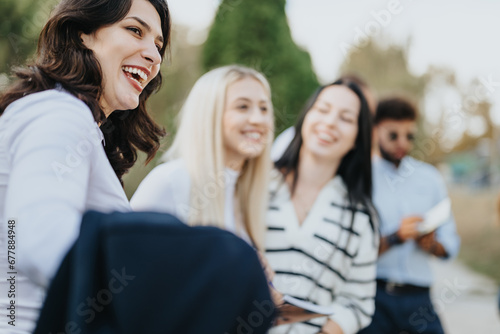 A happy group of young learners studying together in a sunny park, discussing topics and preparing for exams. They are motivated to achieve better results through teamwork and exchanging knowledge.