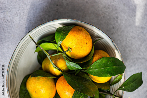 Overhead view of a bowl of fresh ripe tangerines against a grey background photo