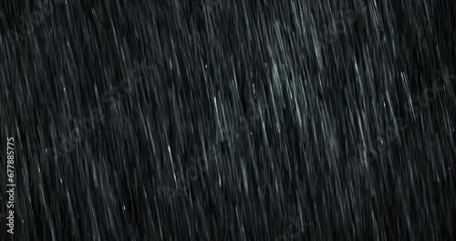 A heavy diagonal rain falls in front of the black screen in 4K loopable high-speed footage. Raindrops splashing. Rain closeup VFX insert. Practical, seamlessly loopable. Heavy rainstorm hitting black. photo