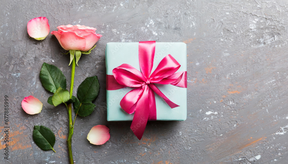 design concept with pink rose flower and gift box on colored table background top view happy holiday mothers day birthday concept romantic flat lay composition design concept with pink rose flower and gift box on colored table background top view happy holiday mothers day birthday concept romantic flat lay composition