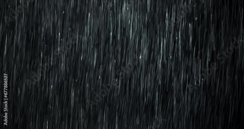 A heavy rain wall falls in front of the black screen in 4K loopable high-speed footage. Raindrops splashing. Rain closeup VFX insert. Practical, seamlessly loopable. Heavy rainstorm hitting black. photo