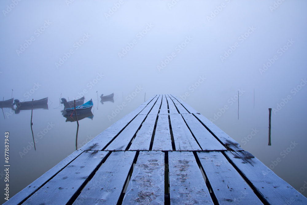 fishing boats on the lake in the fog