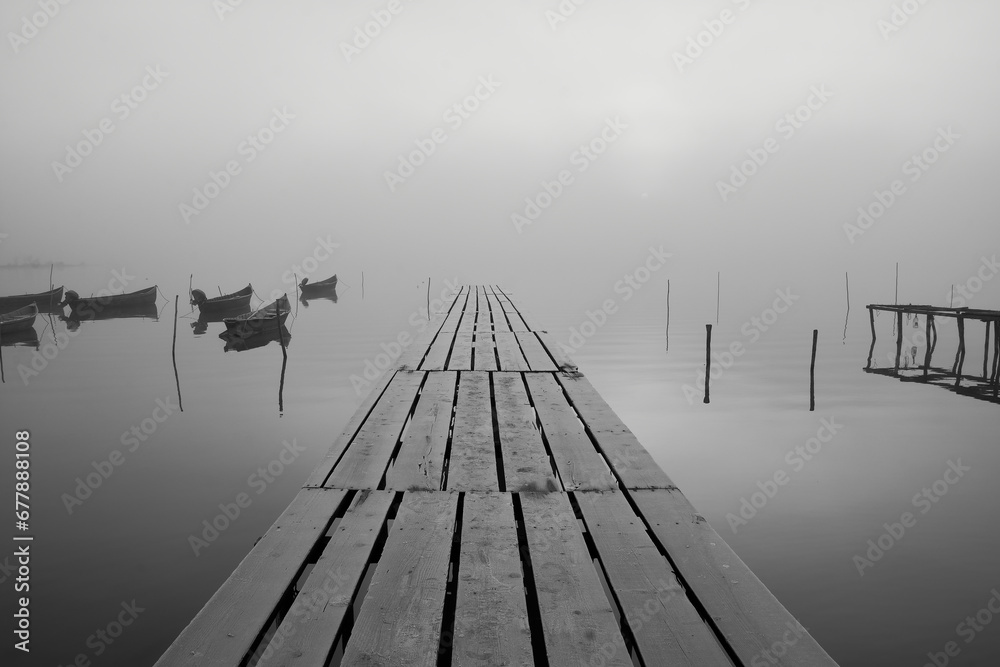 fishing boats on the lake in the fog