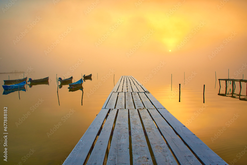 fishing boats on the lake in the fog