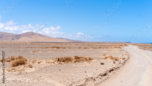 Long emplty lonely dirt road long route ahead volcanic lunar landscape no people, lanzarote, canary islands, spain