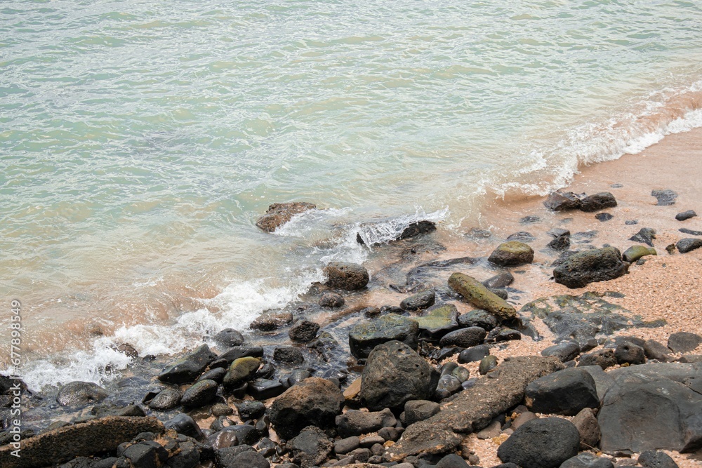 Closeup view of a rocky coastline with a calm sea waves Closeup view of a rocky coastline with a calm sea waves