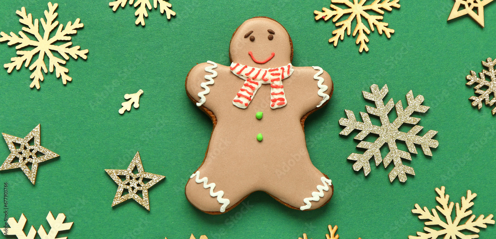 Christmas gingerbread cookie and many snowflakes on green background