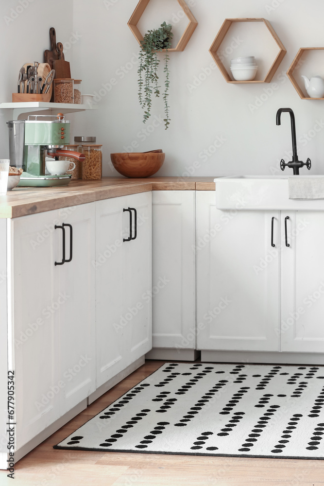 Fototapeta premium Stylish rug with dots on floor in kitchen