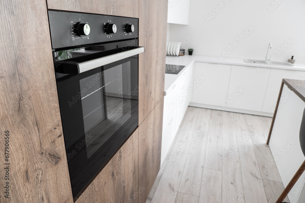 Wooden furniture with modern built-in oven in kitchen Wooden furniture with modern built-in oven in kitchen