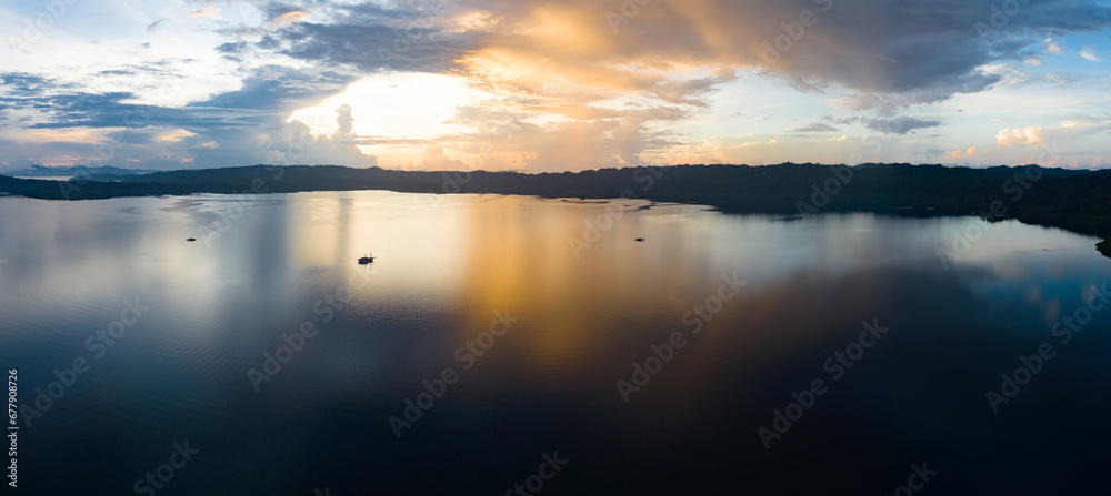 A serene sunrise illuminates the calm seas of Raja Ampat, Indonesia. This remote, equatorial region is known for its high marine biodiversity and is a popular destination for diving and snorkeling. A serene sunrise illuminates the calm seas of Raja Ampat, Indonesia. This remote, equatorial region is known for its high marine biodiversity and is a popular destination for diving and snorkeling.
