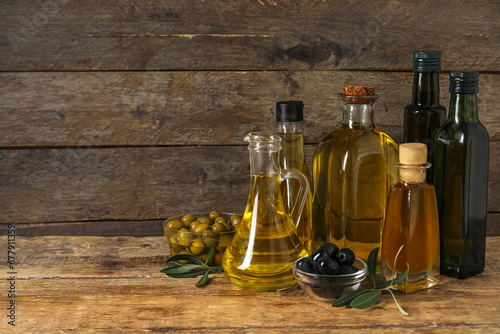 Different glassware with fresh olive oil on wooden background