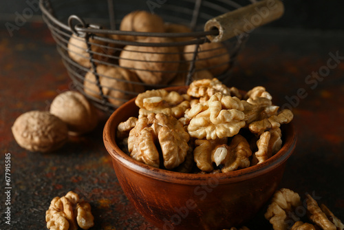 Bowl of tasty walnuts on table