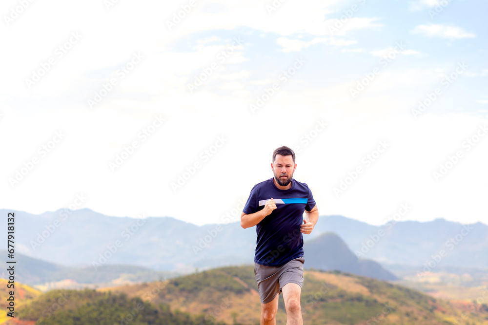 A man running outdoors amid a beautiful landscape. An image to inspire sports and wellness. Excellent for sports events campaigns