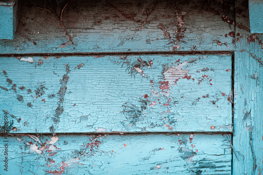 Distressed barn siding with bright teal pain