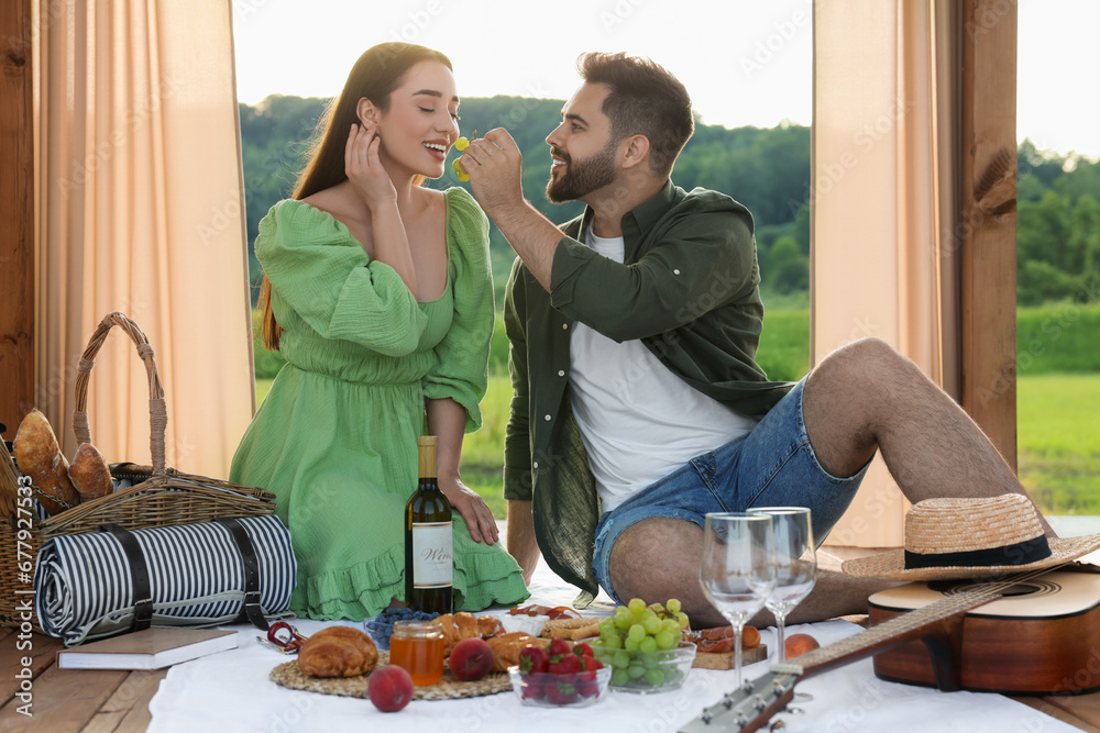 Romantic date. Beautiful couple having picnic in wooden gazebo Romantic date. Beautiful couple having picnic in wooden gazebo