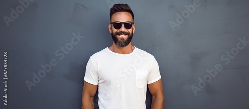 summer an isolated man dressed in a fashionable white and black outfit with a happy smile on his face poses for a portrait as a hipster lifestyle sunglasses model portraying a modern persona photo