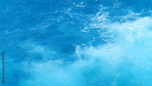 Turquoise ocean sea water white wave splashing deep blue sea. Bird eye view monster wave splash on rock. Tropical sea beach in summer seaside outdoor. Ocean island beautiful dramatic landscape.