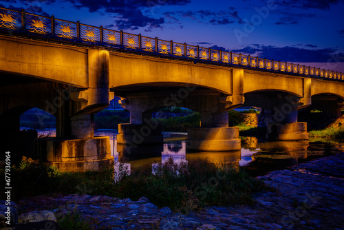 Gyeongju City Sunrise Landscape and dramatic cloudscape at dawn with the view of Seochungyo Bridge over Nam Chon or South River, illuminated by the golden lights, in South Korea