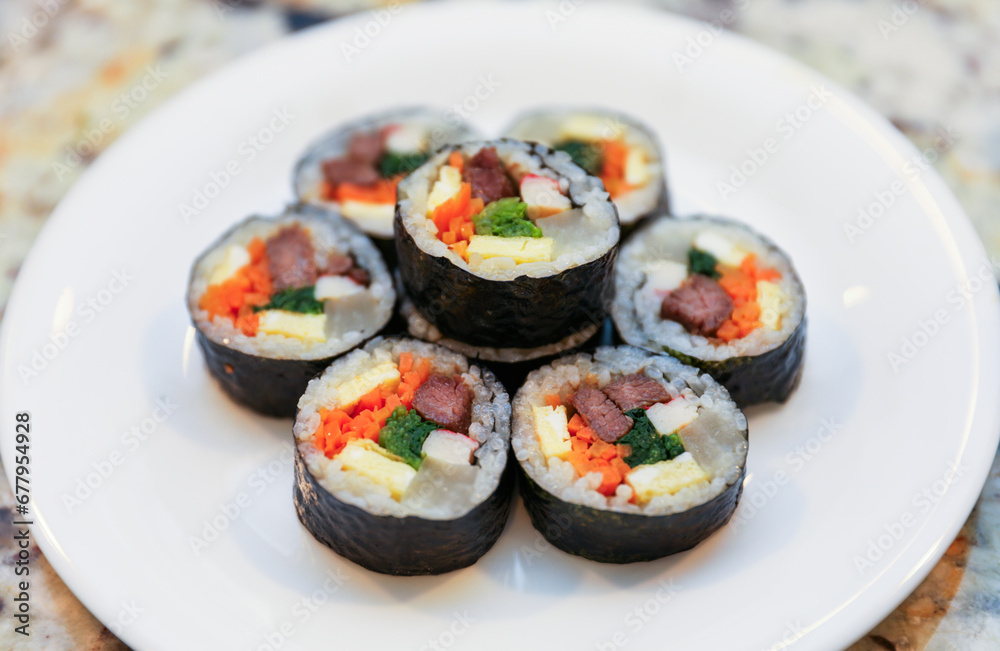 kimbap making, a cherished Korean culinary tradition. Skilled hands roll rice, vegetables, and seaweed, crafting delicious, nutritious bites for an authentic dining experience kimbap making, a cherished Korean culinary tradition. Skilled hands roll rice, vegetables, and seaweed, crafting delicious, nutritious bites for an authentic dining experience