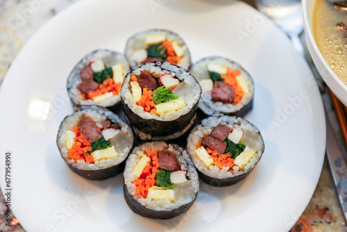 kimbap making, a cherished Korean culinary tradition. Skilled hands roll rice, vegetables, and seaweed, crafting delicious, nutritious bites for an authentic dining experience