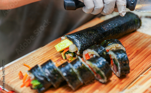 kimbap making, a cherished Korean culinary tradition. Skilled hands roll rice, vegetables, and seaweed, crafting delicious, nutritious bites for an authentic dining experience