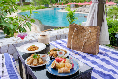 lunch at a restaurant looking out over the swimming pool, and dinner in a restaurant by the pool in Pattaya Thailand. snacks and spaghetti on a table