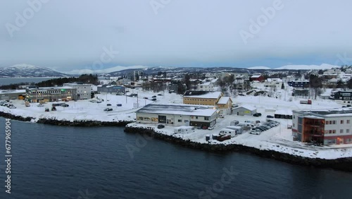 Drone view in Tromso of Finnsnes, a small town full of snow and mountains in the horizon in Norway photo