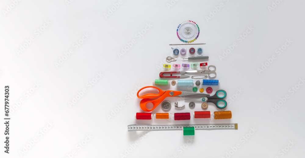 Merry Christmas. Unusual funny Christmas tree made from sewing and craft supplies on white background. Happy New Year greetings to people involved in sewing. Flat lay, closeup, top view, copy space