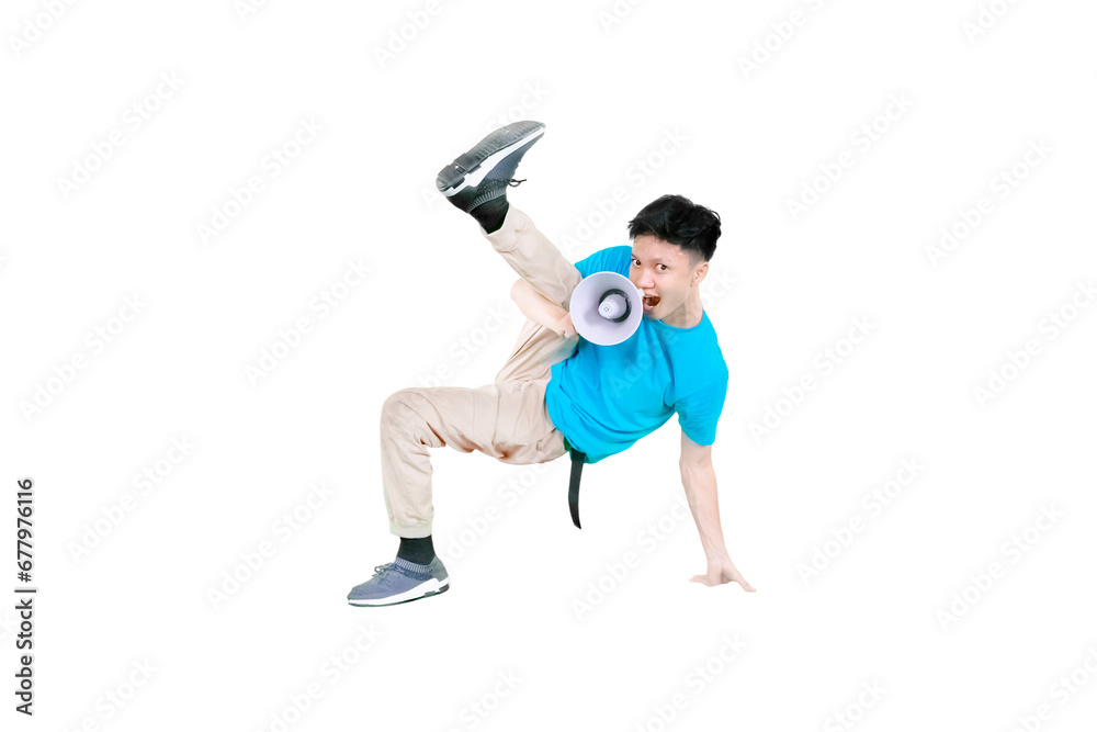 Young guy holding a megaphone while doing some acrobatic moves isolated on white background